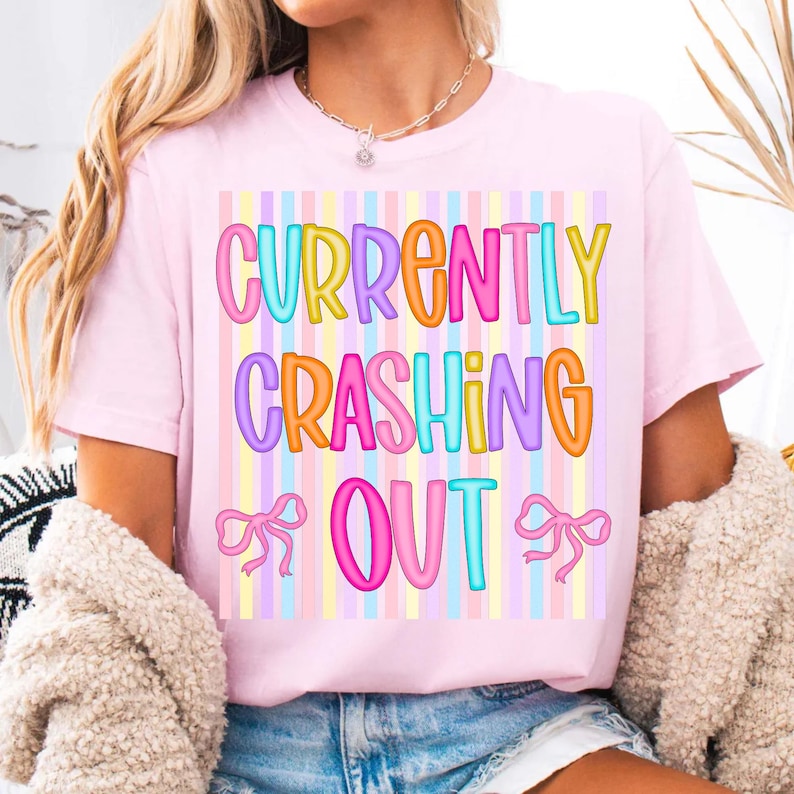 "Currently Crashing Out" PNG sublimation design featuring pastel stripes, bubble letters, and a coquette bow on a white background.