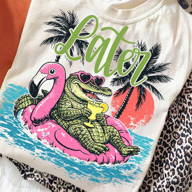 Later Gator PNG design on a white t-shirt, showing the alligator in a flamingo float with a retro sunset background.