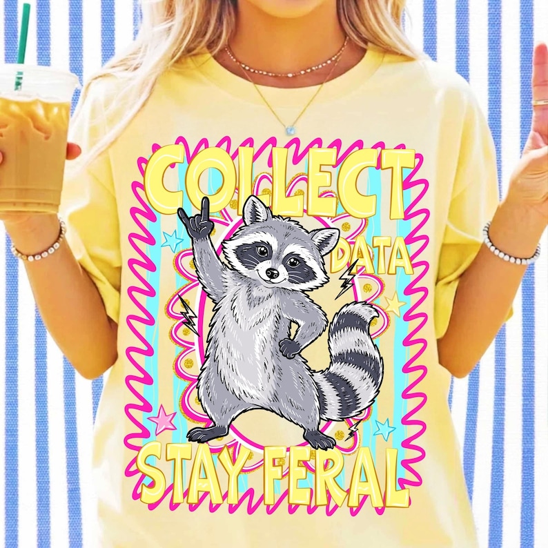 A "Stay Feral" raccoon PNG design featuring a retro preppy style, perfect for sublimation and DTF projects.