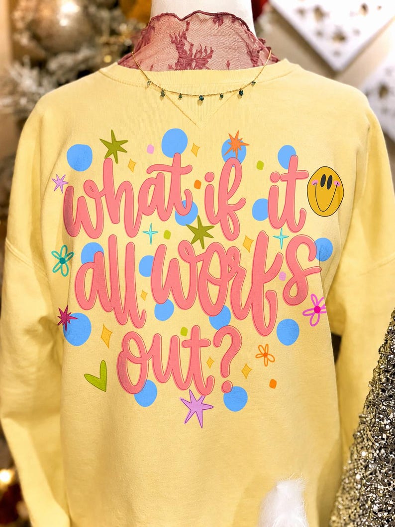 Retro daisy smiley face 'What If It All Works Out' PNG design on a white t-shirt mockup, showcasing preppy positivity.